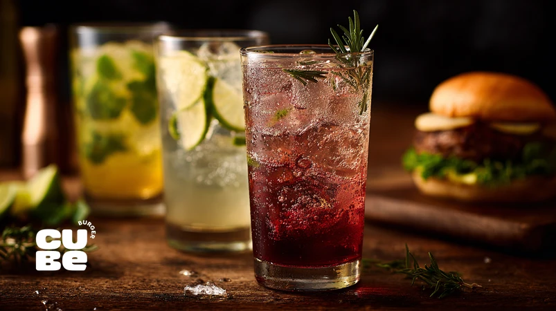 نوشابه‌های دست‌ساز با گاز ملایم و طعم طبیعی کنار برگر دست‌ساز در سبک مجله غذایی حرفه‌ای